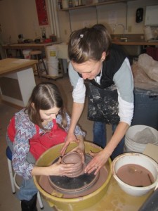 Pottery instructor Megan Crimmins assists Trinity Liddle on the wheel. Wende Carr photo. 