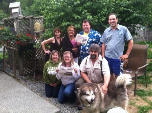 Gathered in Alaska Bill's backyard and holding their Weekly Adirondacks, the group is joined by Bill, Andy Smith, Andy Newton, and Bill's Alaskan Malamute dog Jake. Not pictured but a fun part of the traveling group was Andy Smith's wife Denora