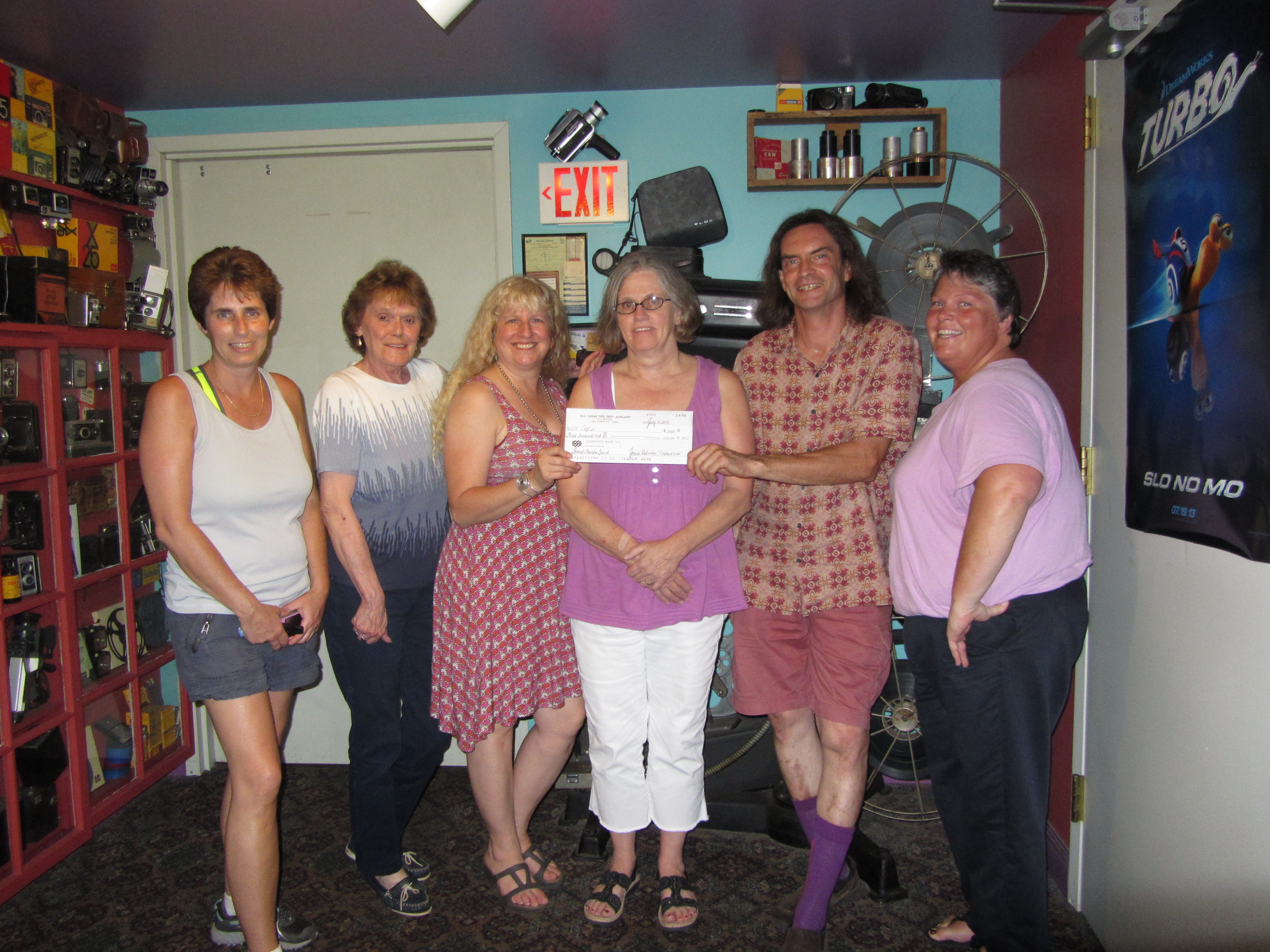 Strand owners Helen Zyma, third from left, and Bob Card received a $3,000 donation for the theater's digital converstion from Old Forge Fire Dept. Auxiliary member Carol Perkins, Joanne Widman, Jane Tormey and Barb Winslow. Photo by Gina Greco