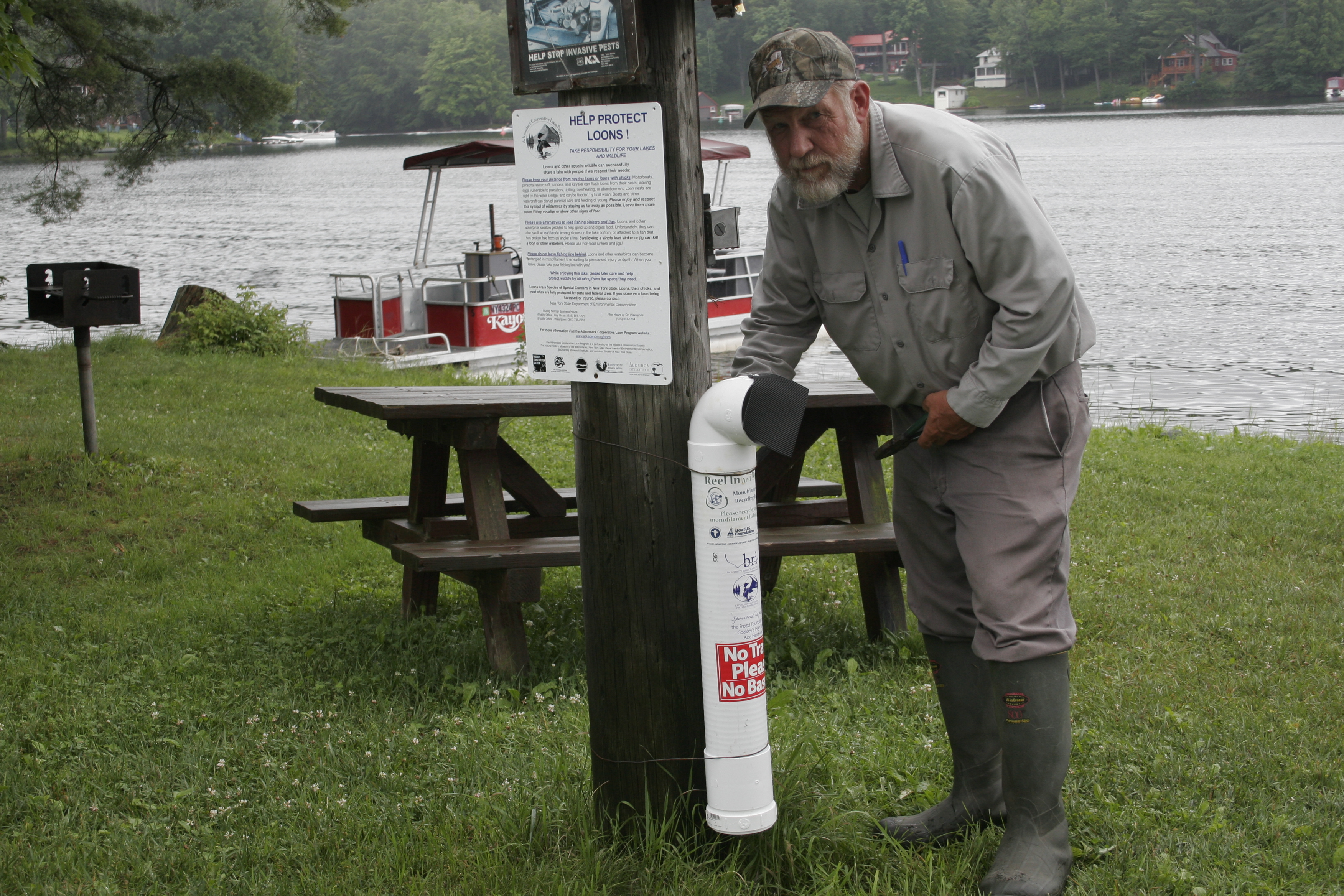 Gary Lee installs a line collection canister at the Fourth Lake Access to Alger Island