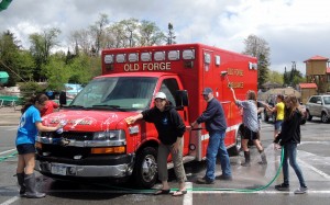 In foreground Diane Amos, Kiwanians Member and Key Club Advisor, and Mike Griffin, Kiwanis President, help wash Old Forge Ambulance 608 with crew Paramedic Dan Rivet and Driver Father Shane Lynch just returning from a call.