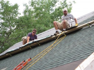 Matt Mitchell, left, and Jim Williams shingle a roof. Photos by Michele deCamp