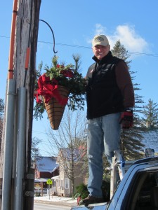 Town of Webb Publicity Director, Mike Farmer, helps hang some greenery. Photos by Gina Greco
