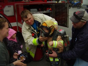 Otter Lake Chief Abrial gearing up a junior firefighter