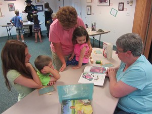Town of Webb school teacher, Judy Ehrensbeck reads a book to reading program children