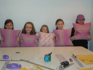 First-time sewing students displaying their finished products